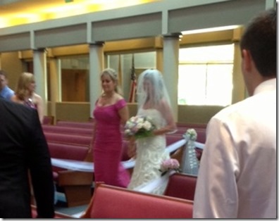 bride and mom walk down the aisle