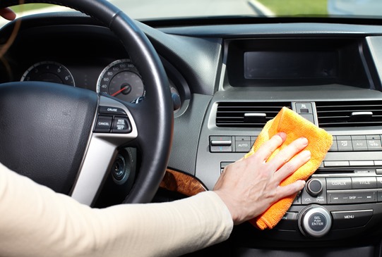 Hand with microfiber cloth cleaning car.
